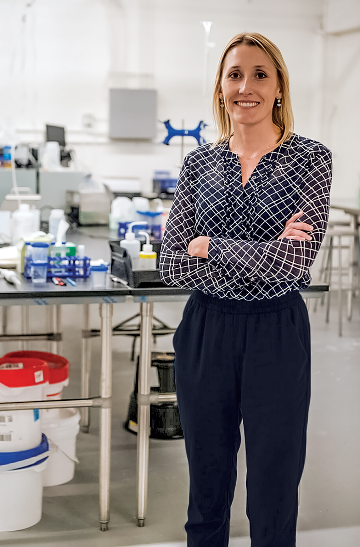 Travertine Technologies' founder and CEO, Laura Lammers, standing on a walkway outside the bench area of the firm's lab