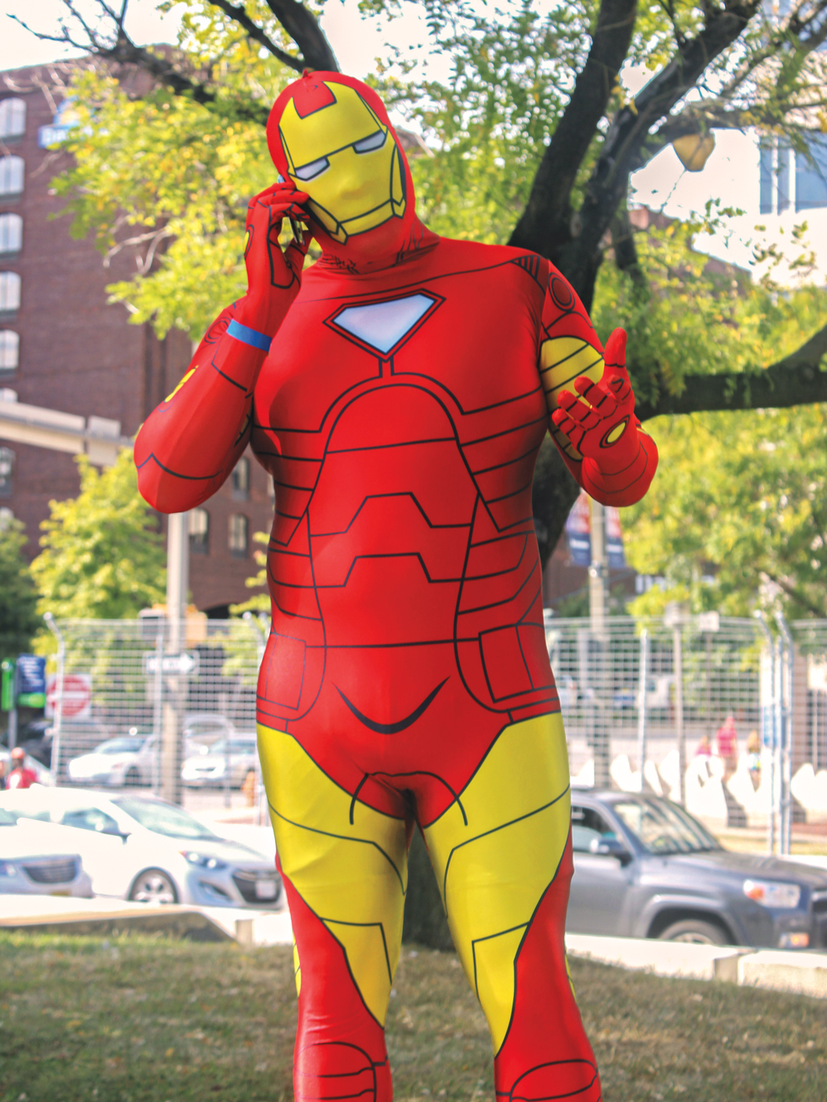 A man in a spandex Iron Man costume takes a phone call.