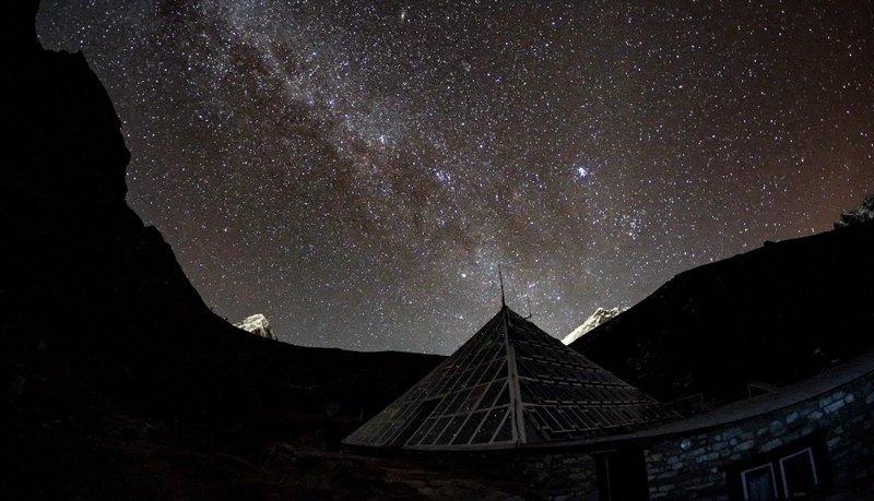 A glass pyramid underneath a star-filled sky.