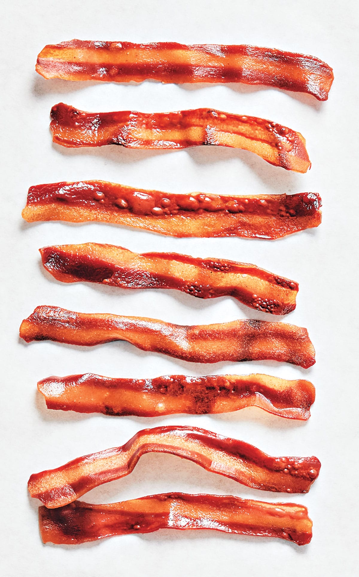 A column of glistening seaweed-based bacon, which looks just like regular bacon, including a stripe of fat on each strip.