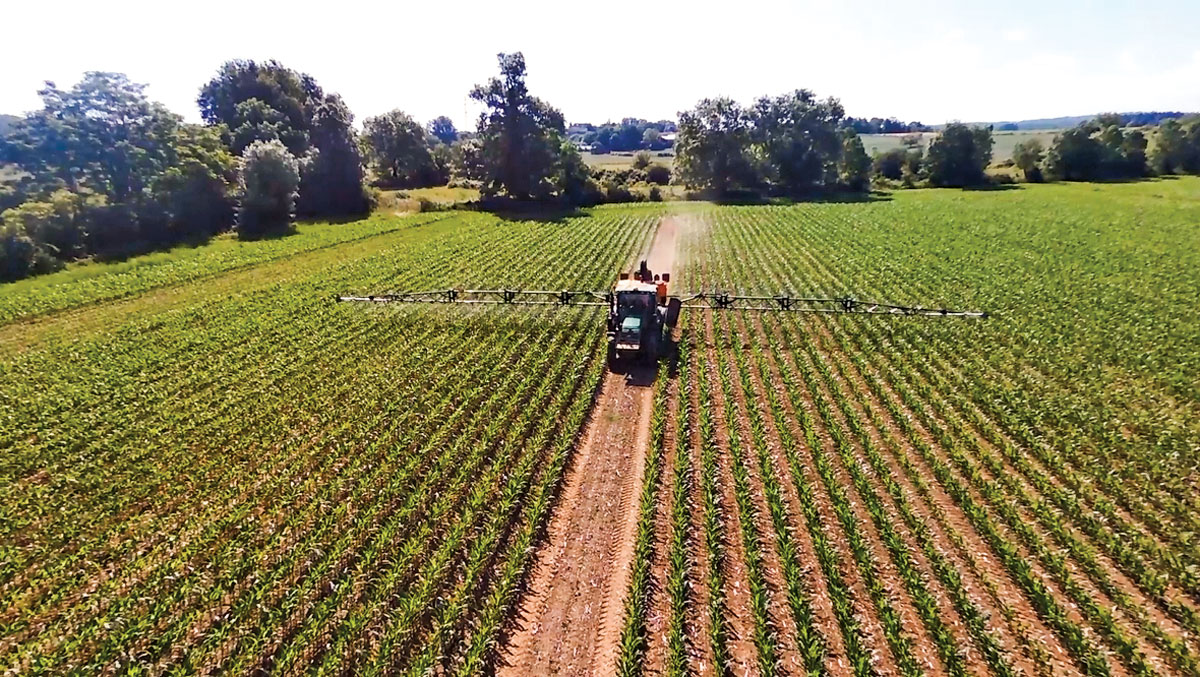 A tractor sprays phytosterols on corn plants on an experimental farm in France.
